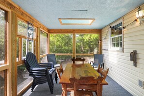 A wooden-paneled room with a large table and chairs, large windows, and a skylight. - Ridgetop Retreat- Minutes from Town, Dog Friendly, Wood Fireplace (Berkeley Springs)