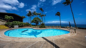 A swimming pool with lounge chairs and palm trees, surrounded by a building with a staircase. - Napili Shores G258 Studio Condo Condo (lahaina)