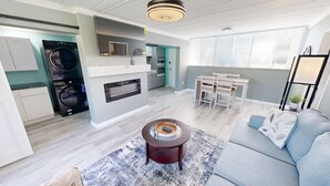 A modern apartment with a kitchen, dining area, and living room.