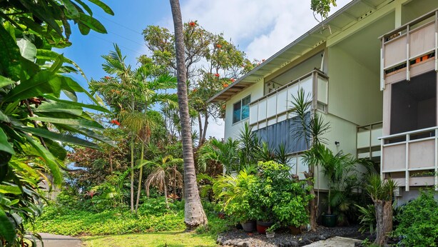 A building with a garden, a pathway, and a palm tree. - Big Island Kona Kai J2 2 Bedroom Condo (Kailua-Kona)