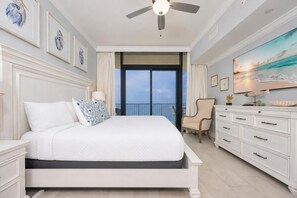 A bedroom with a bed, a dresser, a chair, and a ceiling fan. - Phoenix Gulf Shores Ii 1504 3 Bedroom Condo (Gulf Shores)