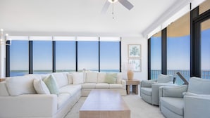 Ein modernes Wohnzimmer mit Ecksofa, Couchtisch und Blick auf den Ozean.
