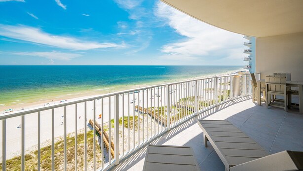 Ein Balkon mit Blick auf Strand und Meer.