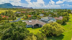 An aerial view of a residential area with houses, roads, and greenery. - Kauai 2247 Loke Road 3 Bedroom Home (Koloa)