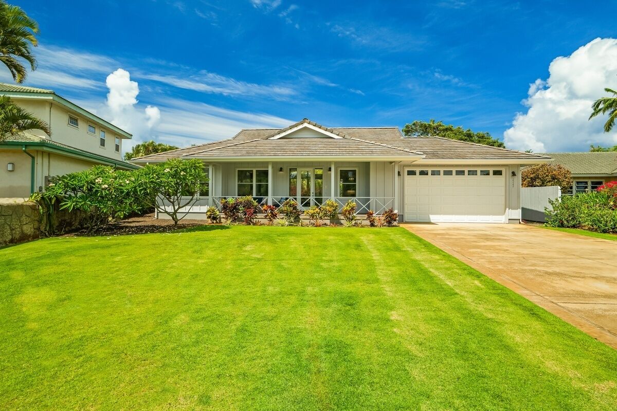 A single-story house with a covered porch, a garage, and a well-maintained lawn.
