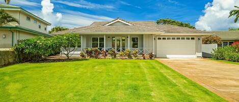 A single-story house with a covered porch, a garage, and a well-maintained lawn.