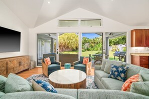 Ein modernes Wohnzimmer mit einem Ecksofa, einem Couchtisch und einem Essbereich mit Stühlen.