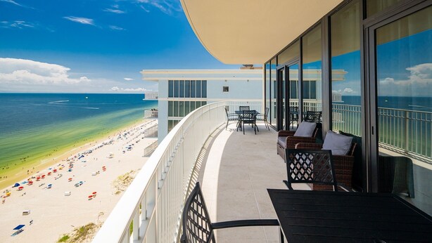 Ein Balkon mit Blick auf Strand und Meer.