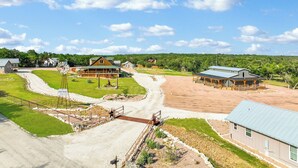 A rural property with a large wooden house, a windmill, and a small building with a metal roof.