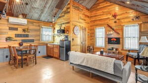 Un acogedor interior de cabaña con cocina, comedor y sala de estar.