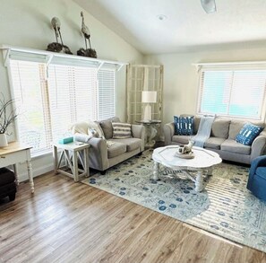 A living room with two sofas, a coffee table, a lamp, and a patterned rug. - Northern Retreat in the Heart of Indian River! (Indian River)