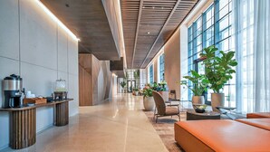 A modern lobby with a long corridor, seating area, and large windows. - Corner 2BR · 42nd Floor Bay & City Views Sleeps 6 (Miami)