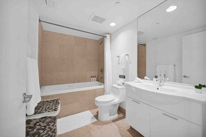 A modern bathroom with a bathtub, toilet, and sink. - Icon Brickell Studio  City View Pool & Spa (Miami)