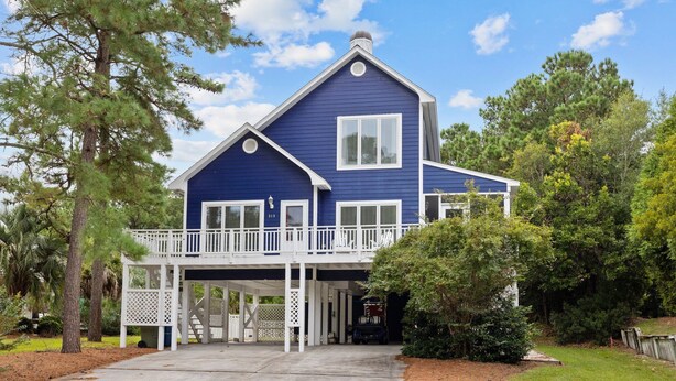 Ein zweistöckiges Haus mit Veranda und Garage.
