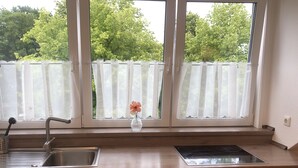 A kitchen with a Bosch dishwasher, a stove, and a sink. - Charming apartment, ideal for longer stays and families (Kiel)