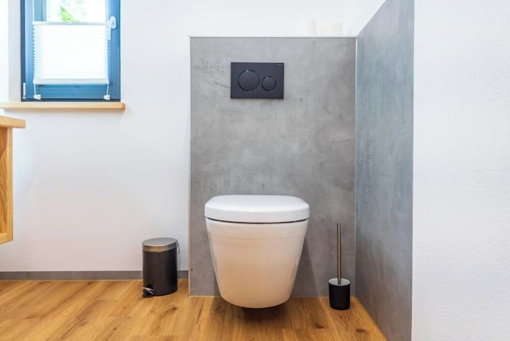 Ein modernes Badezimmer mit Toilette, Mülleimer und Bidet.