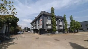 A multi-story building with a modern architectural design, featuring a flat roof and a mix of glass and concrete facades. - Lamonde Hotels by Somewhere (Jos)