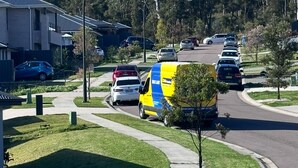 Una calle residencial con casas, una camioneta y cielo despejado.