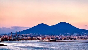 A coastal cityscape with a prominent mountain in the background.