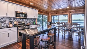 Una cocina moderna con armarios blancos, electrodomésticos de acero inoxidable y una isla grande con taburetes.