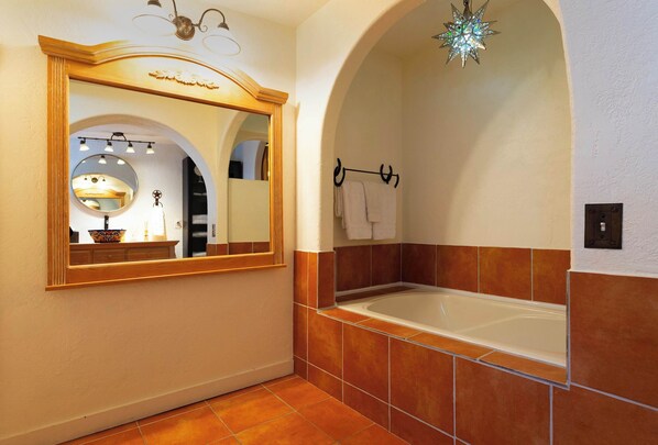 A bathroom with a large mirror, a bathtub, and a star-shaped light fixture.