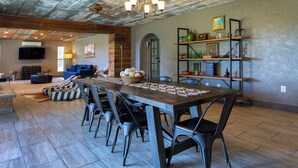 A spacious dining area with a long table, multiple chairs, and a central decorative bowl.