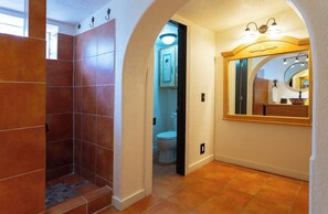 A bathroom with a shower, toilet, and vanity with a mirror. - Willie's Hill Country Hideaway - Family Stay for 8 with Hot Tub & Fire Pit (Wimberley)