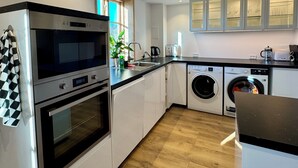 A modern kitchen with a built-in oven, microwave, and washing machine. - Casa de Rainer Tommerup (Tommerup)