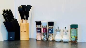 A kitchen counter with various cooking utensils and spice containers.