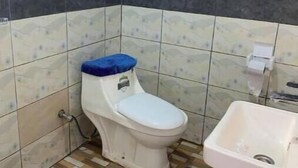 Pieni kylpyhuone, jossa on wc, pesuallas ja ikkuna.