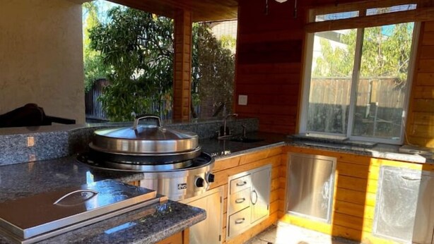 Una cocina compacta con encimeras de granito, estufa integrada y armarios de madera.