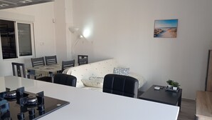 Un espace de vie compact comprenant une kitchenette, un coin repas et un canapé.