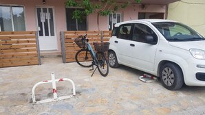 A white car parked in front of a building with a stone-paved entrance.