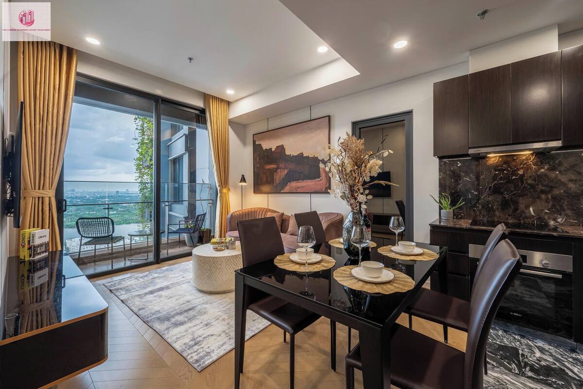 Un salon moderne avec un coin repas, de grandes fenêtres et une cuisine dotée de meubles en bois foncé.