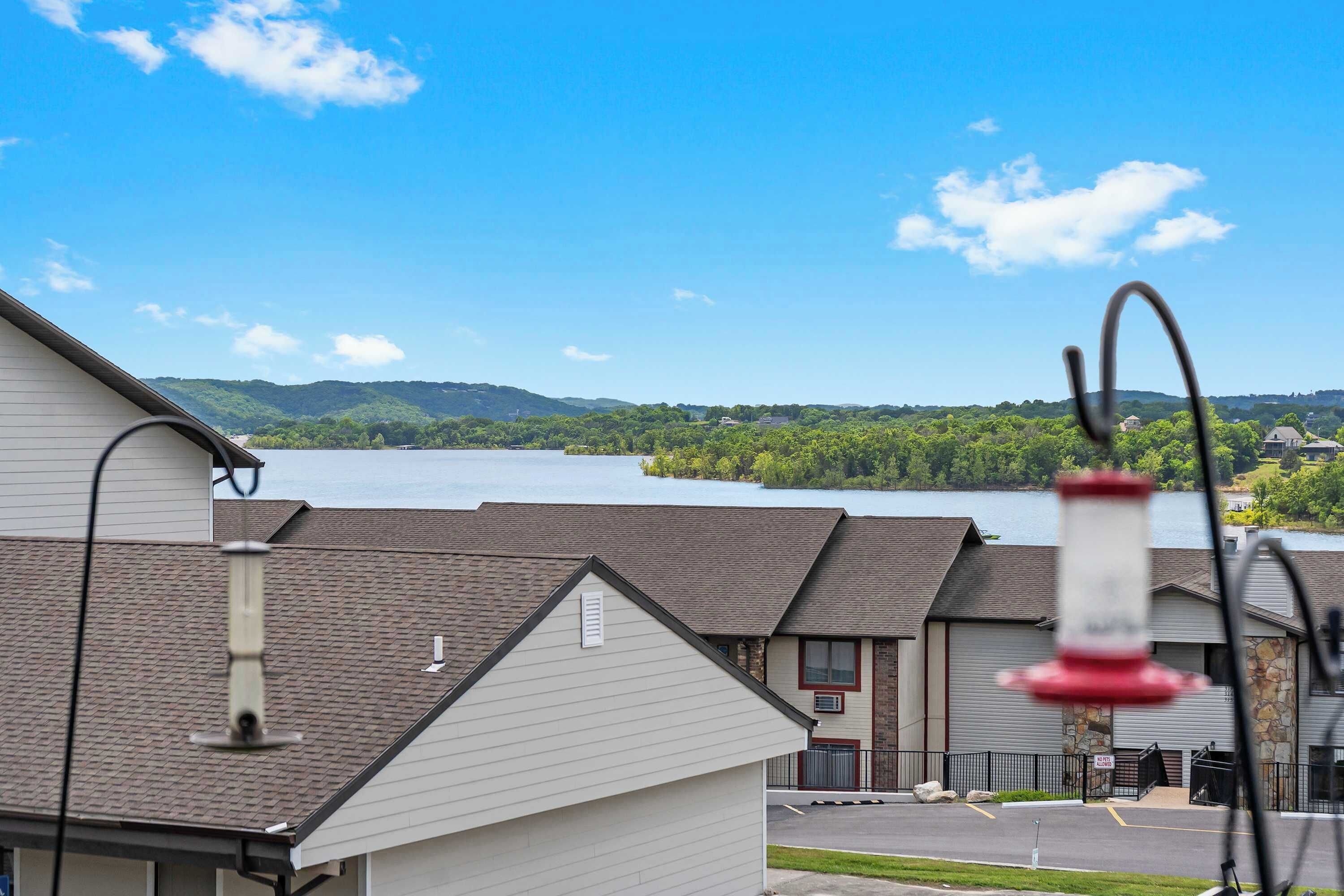 A view of a building with a clear sky and a lake in the background.