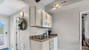 A kitchen with white cabinets, a microwave, a sink, and a coffee maker. - Little Dipper Cozy Condo for 6 w/ Resort-style Amenities (Kimberling City)