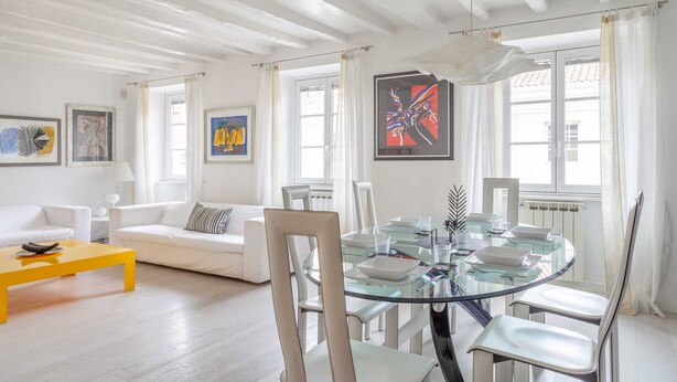 A modern living room with a glass dining table, white sofas, and artwork on the walls. - Trieste - Spiridione (Trieste)