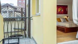 A balcony with a metal railing, a bed with a wooden frame, and a painting on the wall. - Trieste - Spiridione (Trieste)