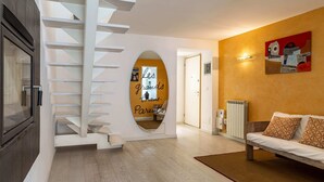 A modern interior with a staircase, a sofa, and a wall with a framed artwork. - Trieste - Spiridione (Trieste)