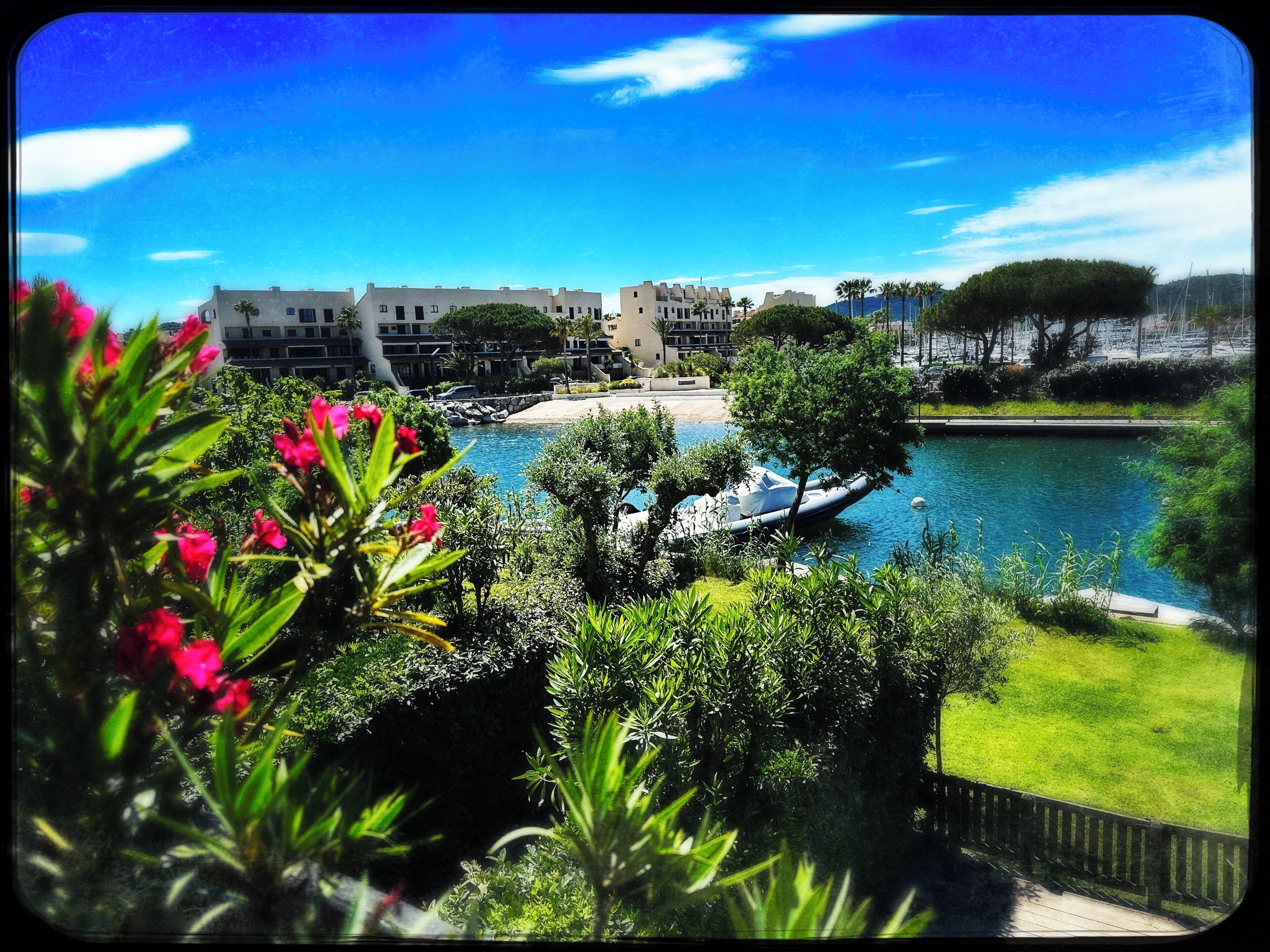 A resort with a pool, a boat, and a view of a beach and buildings.