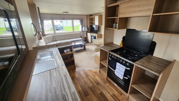 A compact RV kitchen with a stove, sink, and a small dining area. - Petfriendly- Familyfriendly- 8berth- Tattershall (Lincoln)