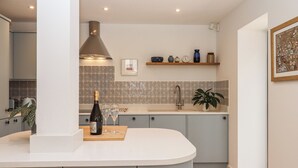 Une cuisine moderne dotée d’un îlot central aux lignes courbes, d’une plaque de cuisson intégrée et d’un dosseret carrelé.