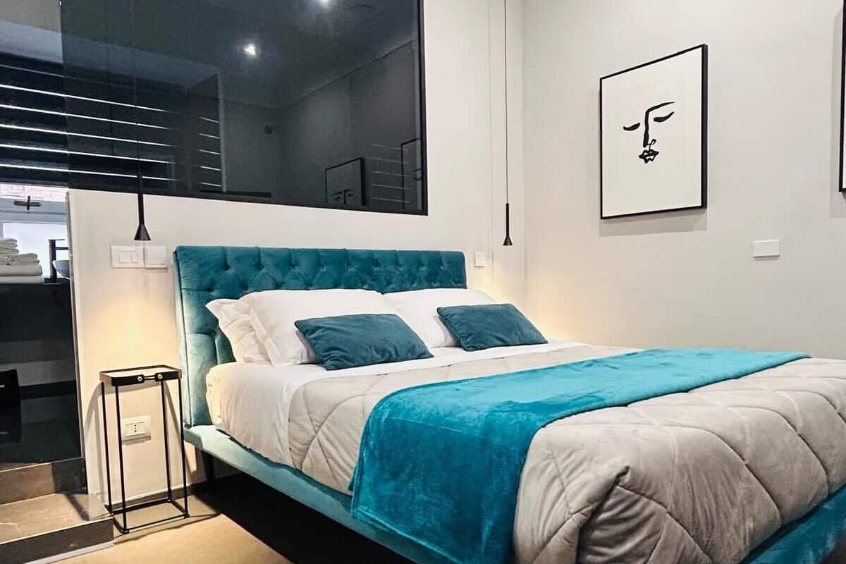 A modern bedroom with a large bed, a view of the city, and a minimalist design.