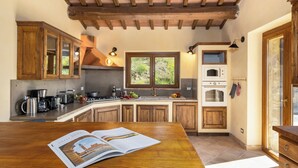 Une cuisine avec des meubles de rangement en bois, une cuisinière et une fenêtre.