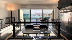 Quarto moderno com uma grande janela para um areal marítimo e o mar.