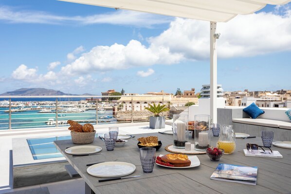 A rooftop dining area with a view of the marina and cityscape.