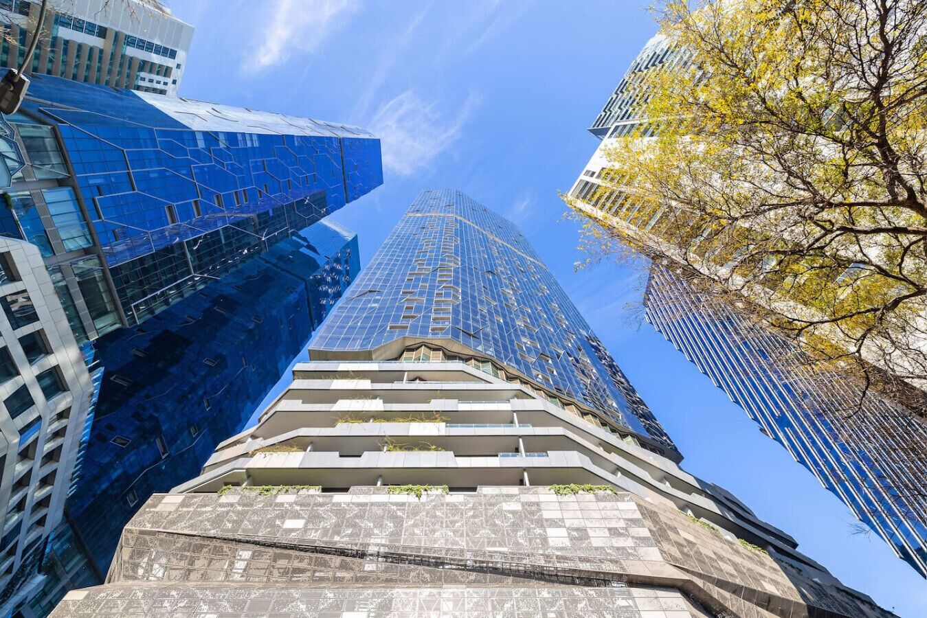 Un immeuble moderne de grande hauteur, doté d’une façade en verre et d’un design original à étages décalés à sa base.