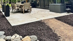 A modern house with a sloped roof, large windows, and a patio with outdoor furniture. - Scenic 3-bedroom Aframe with WiFi and AC on Three Lakes Chain (Three Lakes)