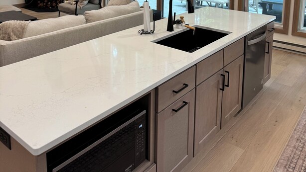 A modern kitchen with a large island, built-in appliances, and large windows offering a view of the forest. - Scenic 3-bedroom Aframe with WiFi and AC on Three Lakes Chain (Three Lakes)