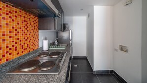 Una cocina moderna con encimera de granito, electrodomésticos de acero inoxidable y un vibrante mosaico en la pared.